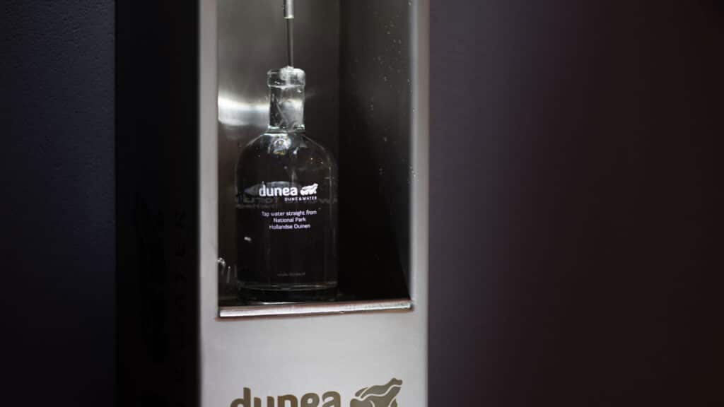 Duinea duinwater fles in glazen vitrinekast bij World Forum evenementenlocatie