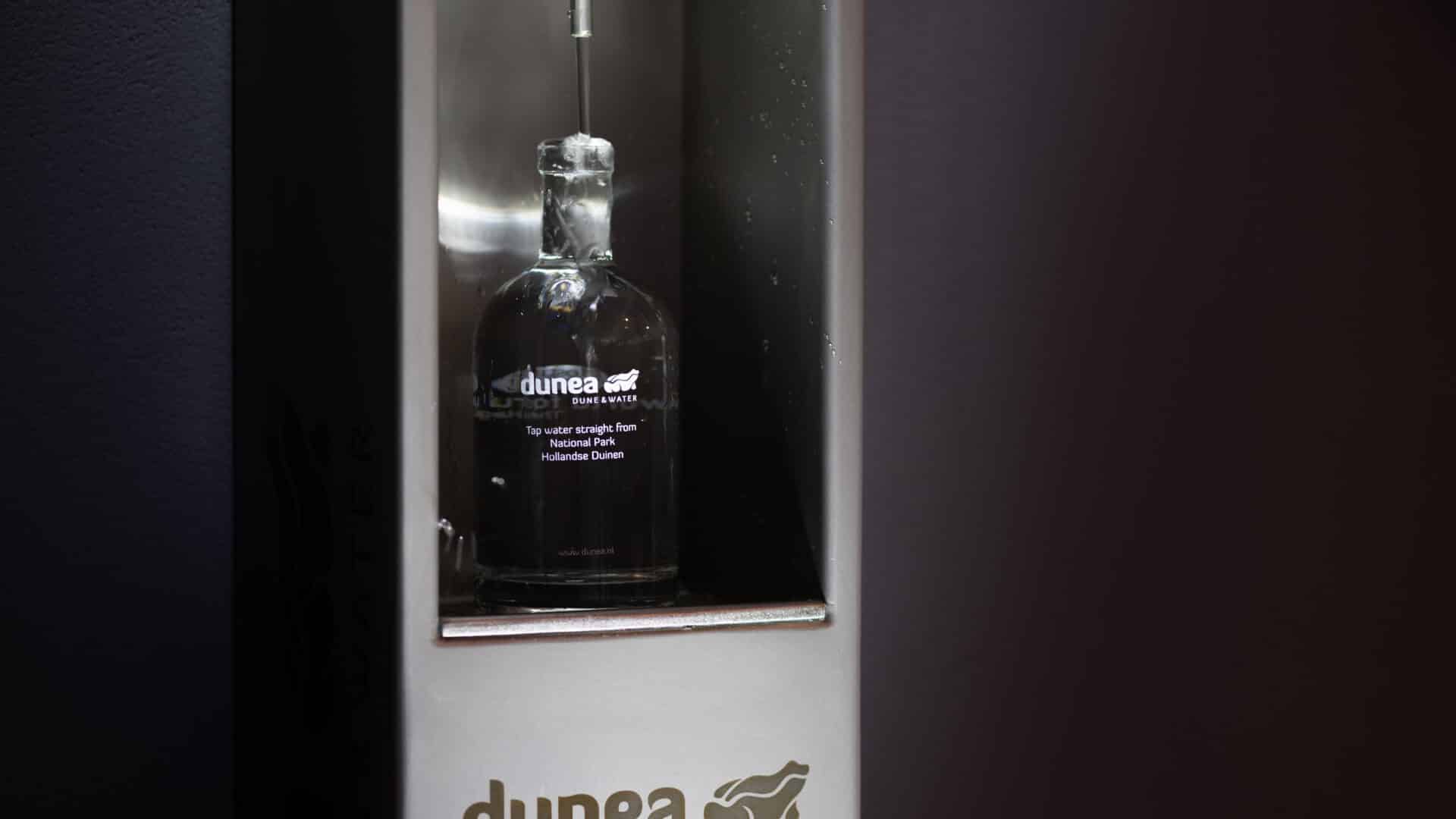Duinea duinwater fles in glazen vitrinekast bij World Forum evenementenlocatie